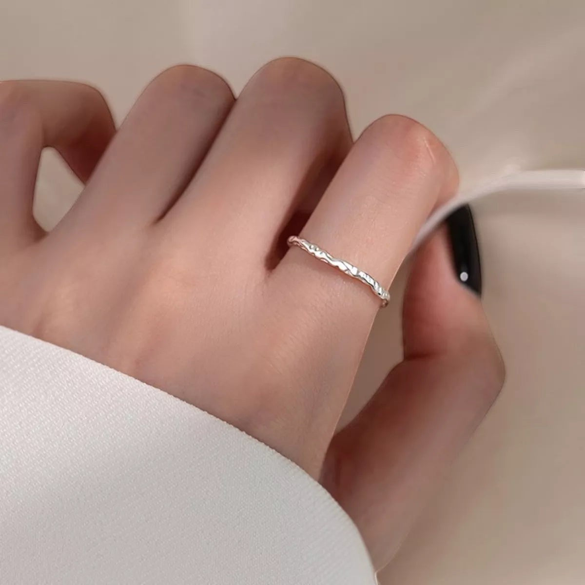 Sfeerfoto van de hand van een model die de subtiele, verstelbare ModaMelhor ring van 925 sterling zilver met gehamerde textuur elegant draagt.