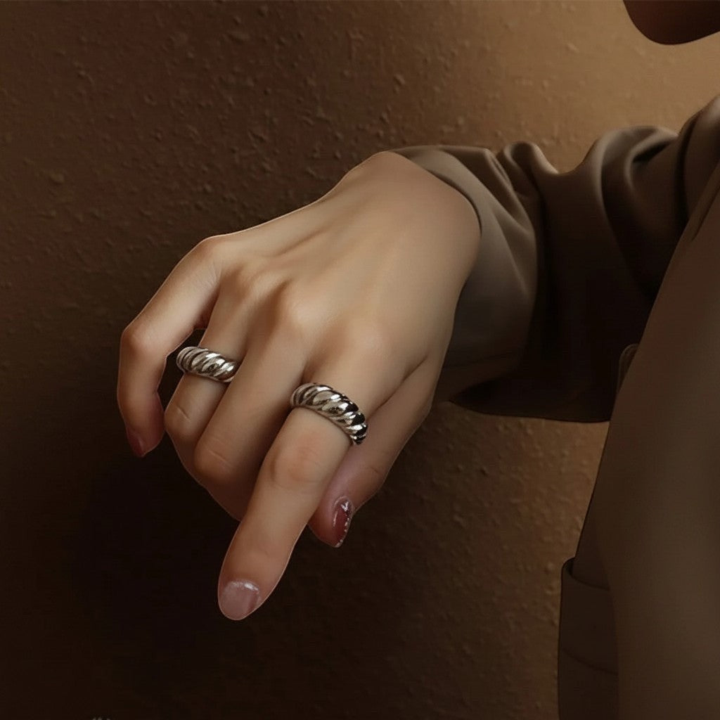 Sfeerfoto van de hand van een model die de zilverkleurige ModaMelhor ringen van titanium staal met een geribbeld ontwerp stijlvol draagt.