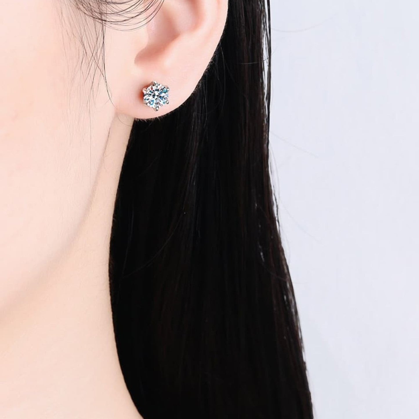 Zijaanzicht van een model dat het ModaMelhor Classic Solitaire oorknopje van 925 sterling zilver met 1 CT moissanite steen in het oor draagt.