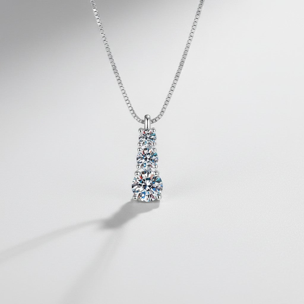 Close-up van de ModaMelhor hanger van 925 sterling zilver met drie sprankelende moissanite stenen die verticaal onder elkaar zijn geplaatst.