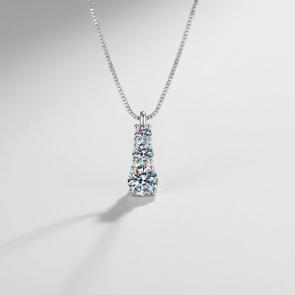 Close-up van de ModaMelhor hanger van 925 sterling zilver met drie sprankelende moissanite stenen die verticaal onder elkaar zijn geplaatst.