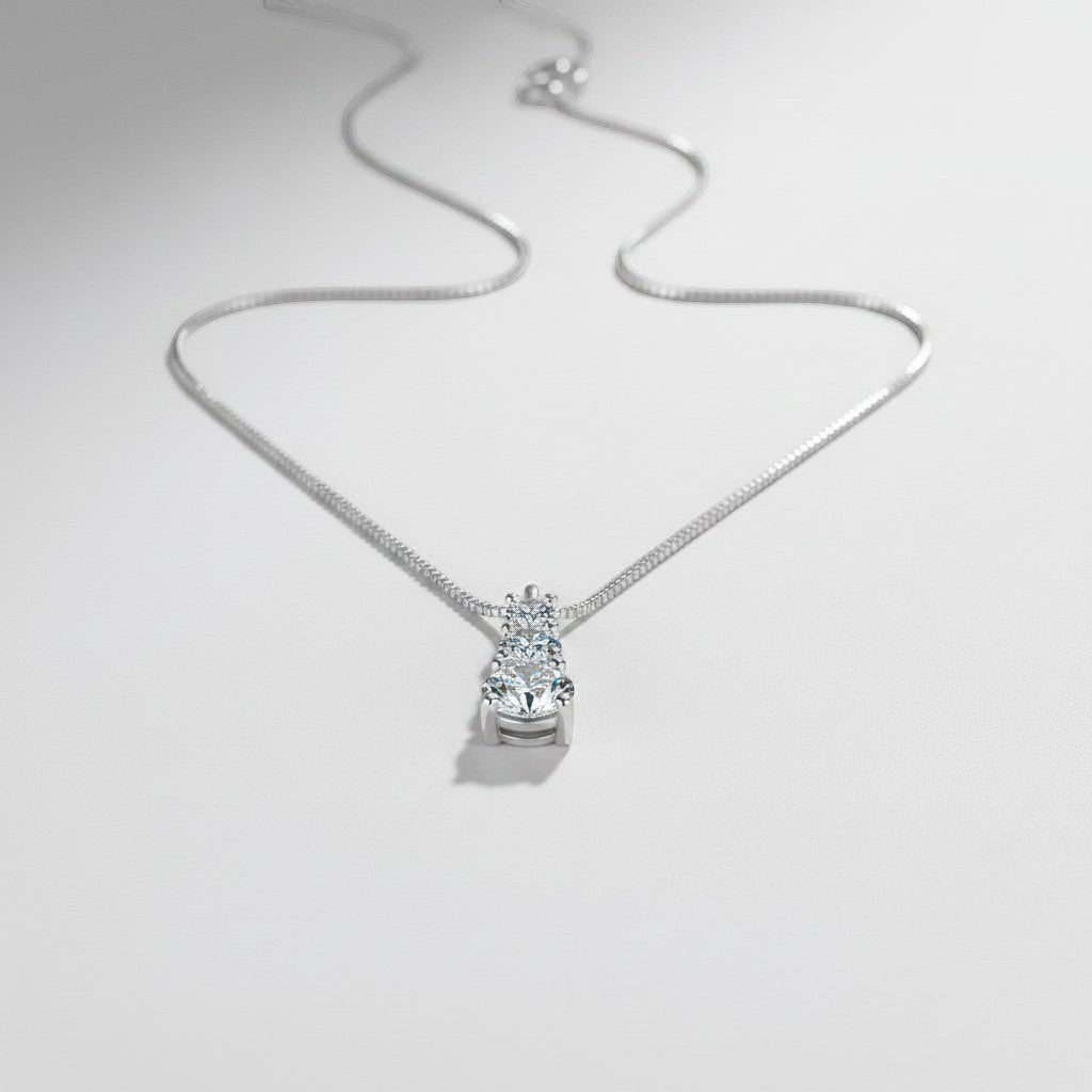 Vooraanzicht van de ModaMelhor zilveren ketting met een hanger waarin drie ronde moissanite stenen verticaal in grootte oplopen.