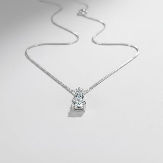 Vooraanzicht van de ModaMelhor zilveren ketting met een hanger waarin drie ronde moissanite stenen verticaal in grootte oplopen.