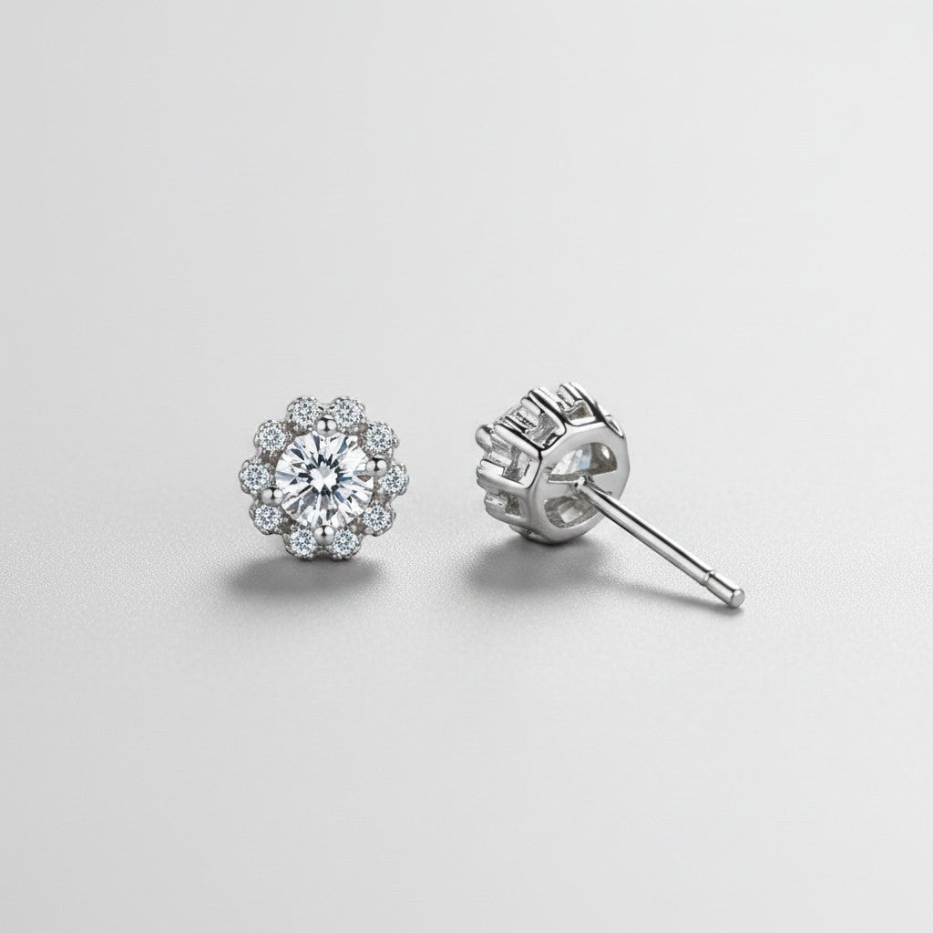 Vooraanzicht en zijaanzicht van de platliggende ModaMelhor bloemvormige oorbellen van 925 sterling zilver met een centrale moissanite steen en zirkonia accenten.