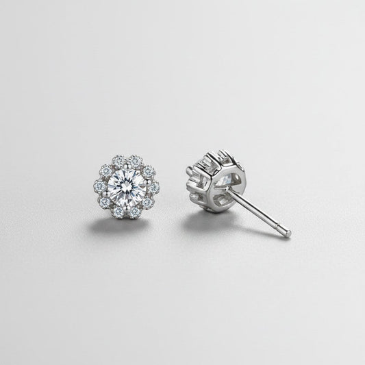 Vooraanzicht en zijaanzicht van de platliggende ModaMelhor bloemvormige oorbellen van 925 sterling zilver met een centrale moissanite steen en zirkonia accenten.