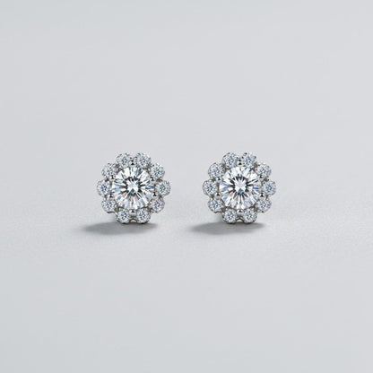 Symmetrisch vooraanzicht van het paar ModaMelhor bloemvormige oorknopjes van 925 sterling zilver met sprankelende moissanite stenen en zirkonia accenten.