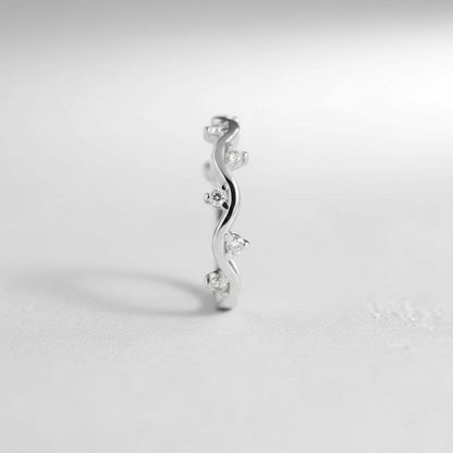 Zijaanzicht van de rechtopstaande ModaMelhor ring van 925 sterling zilver, met een duidelijke focus op het golvende patroon en de ingelegde zirkonia steentjes.
