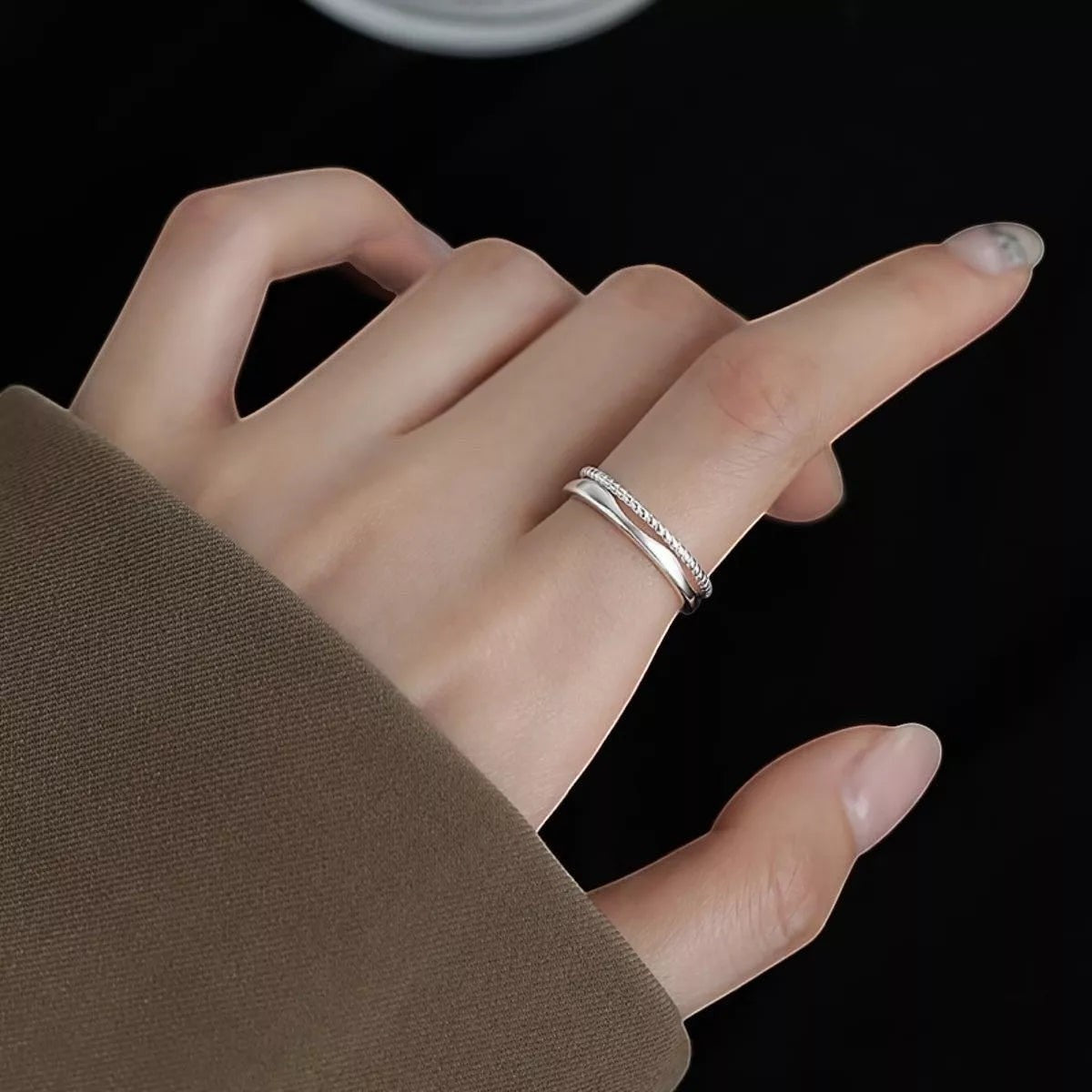 Sfeerfoto van de hand van een model die de verstelbare ModaMelhor ring van platina op 925 sterling zilver met dubbele band elegant draagt.