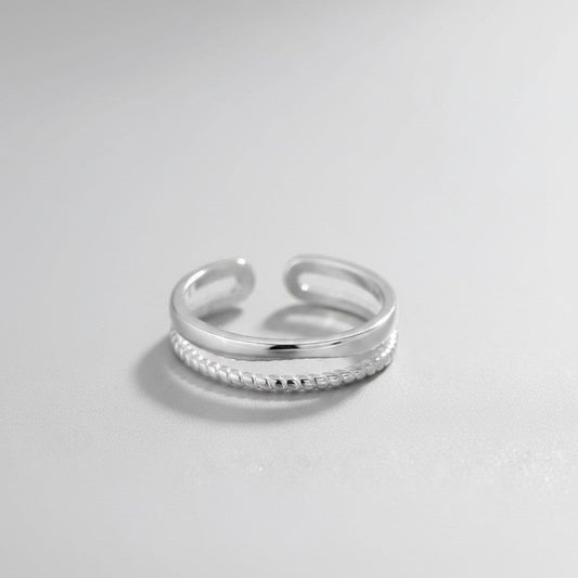 Zijaanzicht van de platliggende, verstelbare ModaMelhor ring van platina op 925 sterling zilver, met een dubbel band-ontwerp en een open achterzijde.