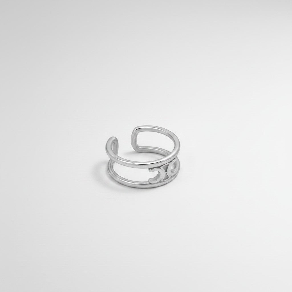 Schuin vooraanzicht van de ModaMelhor zilverkleurige open ring van titanium staal, met een focus op het dubbele bandenontwerp en het subtiele verbindingsdetail.