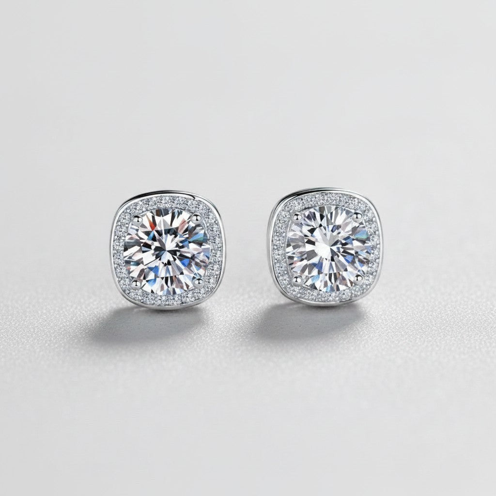 Vooraanzicht van de twee platliggende ModaMelhor Geometric Square oorknopjes van 925 sterling zilver met 1 CT moissanite stenen en een geometrische halo van zirkonia.