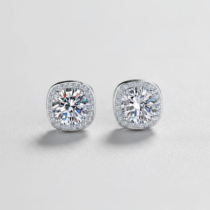 Vooraanzicht van de twee platliggende ModaMelhor Geometric Square oorknopjes van 925 sterling zilver met 1 CT moissanite stenen en een geometrische halo van zirkonia.
