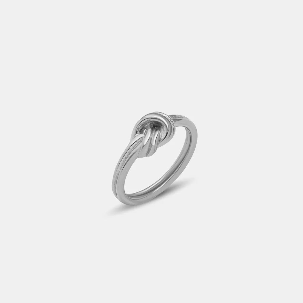 Schuin aanzicht van de ModaMelhor zilverkleurige open ring van hoogwaardig titanium staal met het minimalistische knoopdesign.