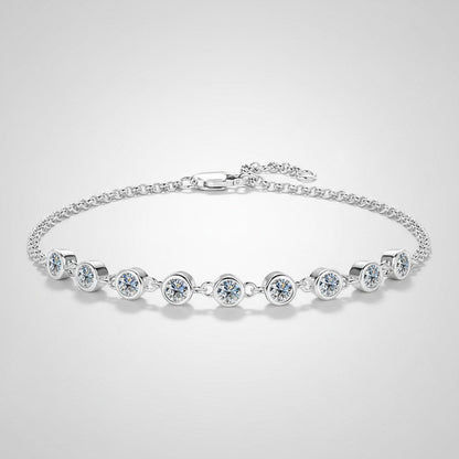 Detailopname van de ModaMelhor zilveren armband van 925 sterling zilver met een rij ronde, in zilver gevatte moissanite stenen aan de voorkant tegen een lichtgrijze achtergrond.