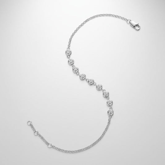 Studio-opname van de ModaMelhor zilveren armband van 925 sterling zilver, elegant neergelegd in een S-vorm op een egale lichtgrijze achtergrond, bezet met een rij glanzende moissanite stenen en voorzien van een karabijnsluiting.