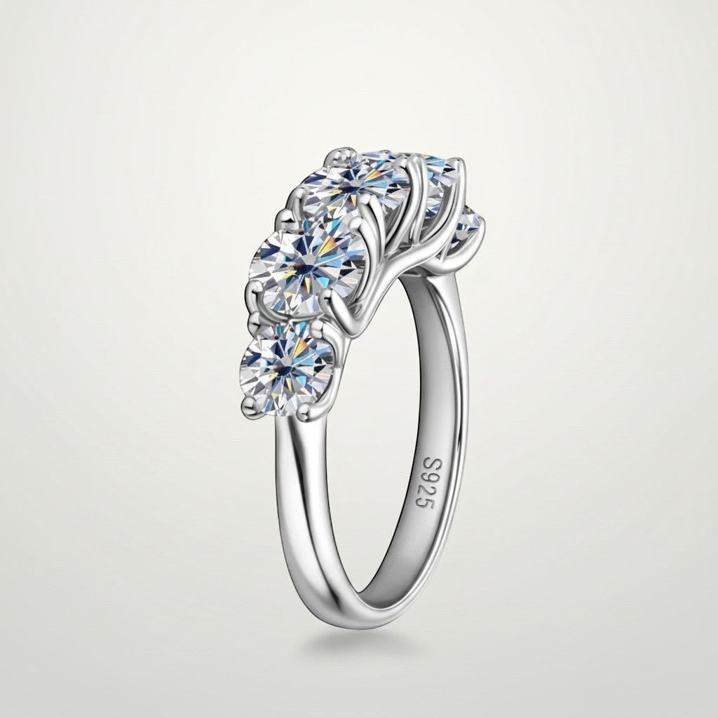 Schuin vooraanzicht van de luxe ModaMelhor 925 sterling zilveren ring, met een focus op de rij van vijf grote Moissanite stenen en de S925 stempel aan de binnenzijde.