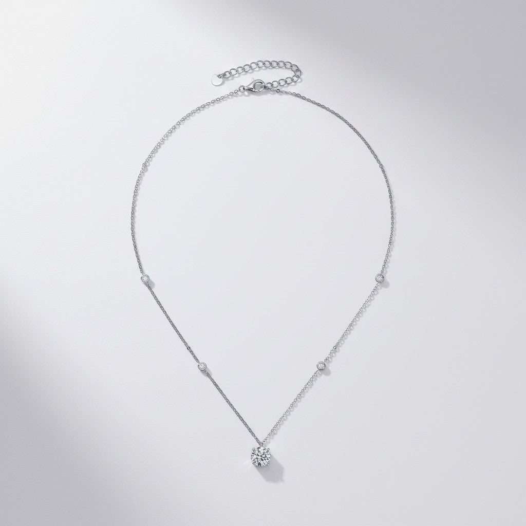 Overzicht van de sterling silver ModaMelhor minimalistische ketting met een ronde 2 karaat moissanite hanger en kleine zirkonia accentsteentjes langs de ketting.