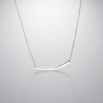 Overzicht van de ModaMelhor zilveren ketting met een strakke, minimalistisch gebogen buisvormige hanger van 925 sterling zilver tegen een reflecterende achtergrond.