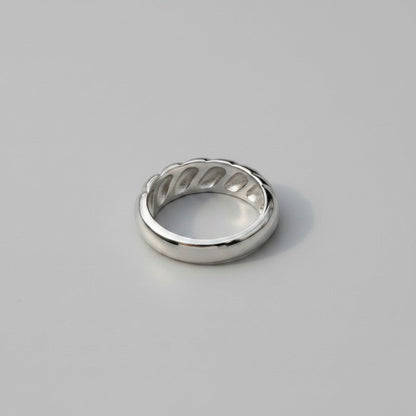 Achteraanzicht van de zilverkleurige ModaMelhor ring van titanium staal, met een focus op de binnenzijde waarin de holtes van het geribbelde ontwerp zichtbaar zijn.