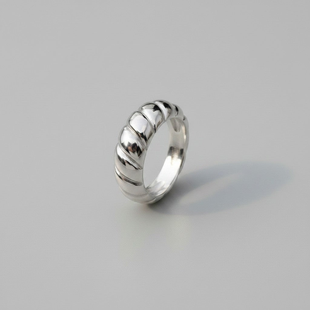 Schuin bovenaanzicht van de zilverkleurige ModaMelhor ring van titanium staal met een minimalistisch en stijlvol geribbeld ontwerp.
