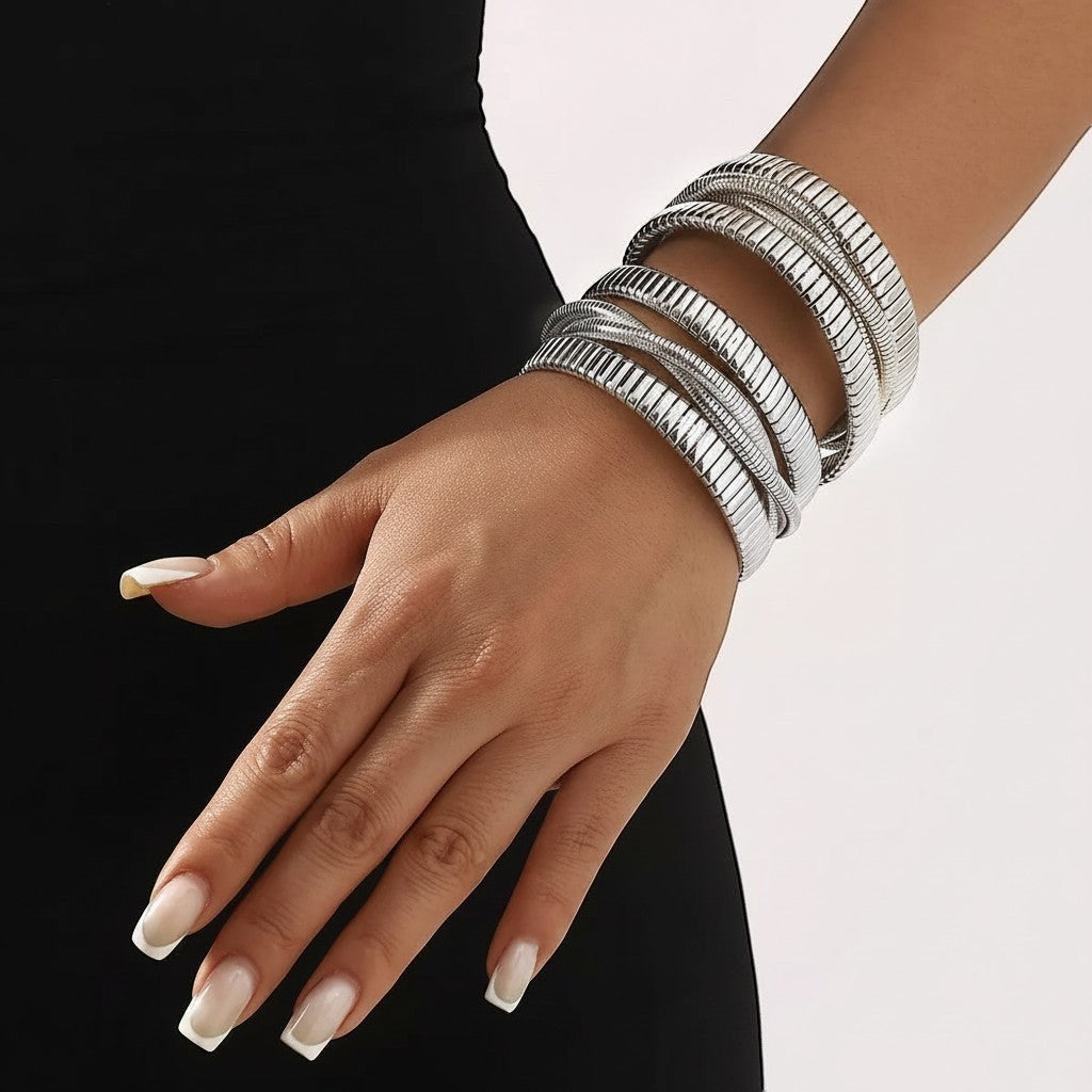 Zijaanzicht van een model dat de brede, meerlaagse ModaMelhor zilverkleurige roestvrijstalen bangle armband om de pols draagt bij een zwarte jurk.