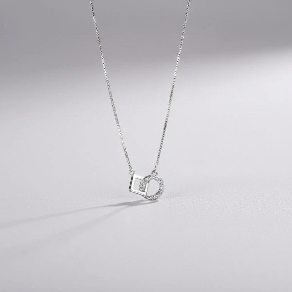 Gedetailleerd vooraanzicht van de ModaMelhor zilveren ketting met de geometrische hanger bestaande uit een in elkaar gehaakt glad vierkant en een met zirkonia bezette cirkel.