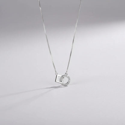 Gedetailleerd vooraanzicht van de ModaMelhor zilveren ketting met de geometrische hanger bestaande uit een in elkaar gehaakt glad vierkant en een met zirkonia bezette cirkel.