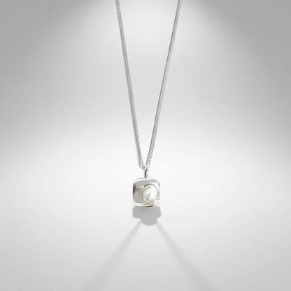 Gedetailleerd vooraanzicht van de ModaMelhor hanger van 925 sterling zilver met een modern, vierkant frame waarin een glanzende zoetwaterparel is ingelegd.