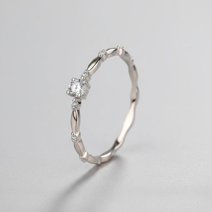 Schuin vooraanzicht van de ModaMelhor zilveren solitair ring, die het verfijnde golvende patroon en de schittering van de ronde moissanite steen prachtig toont.