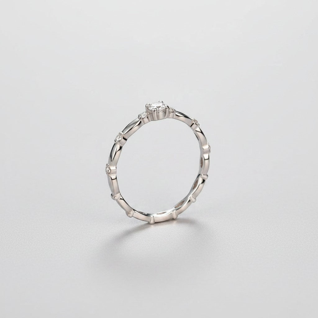 Zijaanzicht van de ModaMelhor zilveren solitair ring, waarbij de verhoogde zetting van de moissanite en het golvende patroon van de band goed te zien zijn.