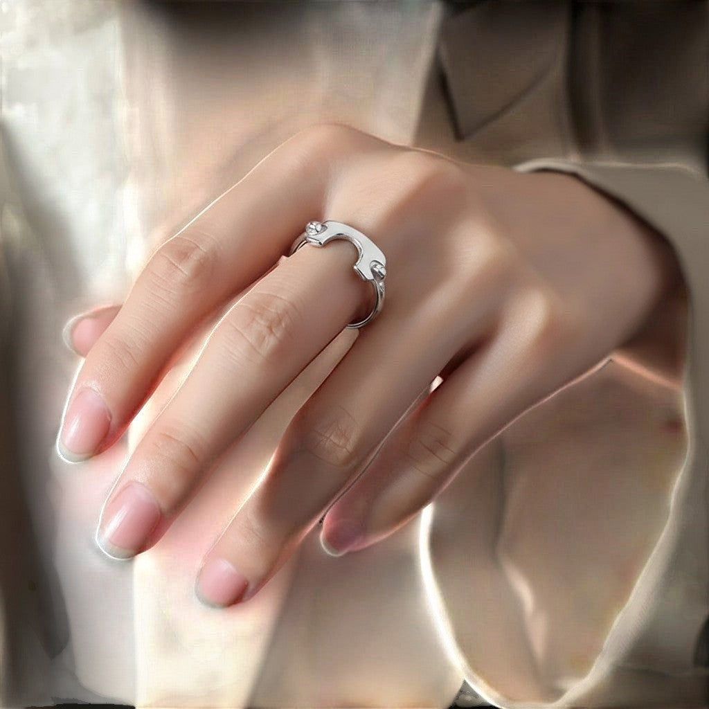 De hand van een model die de zilverkleurige ModaMelhor open ring van titanium staal met het geometrische design elegant draagt.