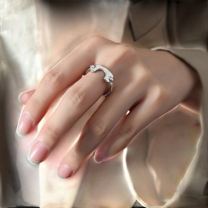 De hand van een model die de zilverkleurige ModaMelhor open ring van titanium staal met het geometrische design elegant draagt.