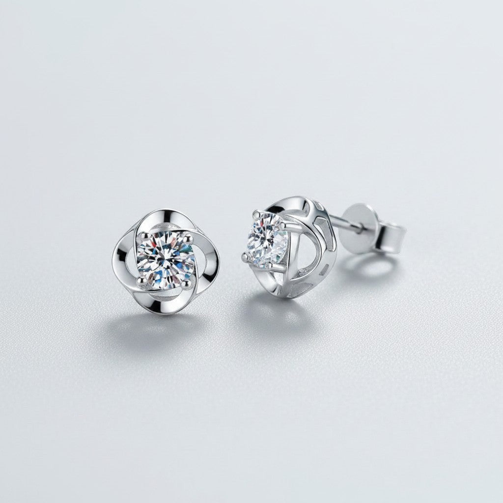 Vooraanzicht en zijaanzicht van de platliggende ModaMelhor spiraalvormige oorknopjes van 925 sterling zilver met centraal geplaatste moissanite stenen.