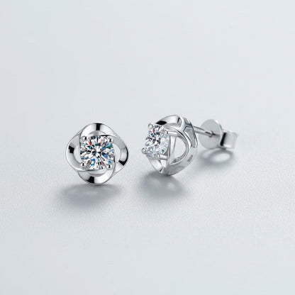 Vooraanzicht en zijaanzicht van de platliggende ModaMelhor spiraalvormige oorknopjes van 925 sterling zilver met centraal geplaatste moissanite stenen.
