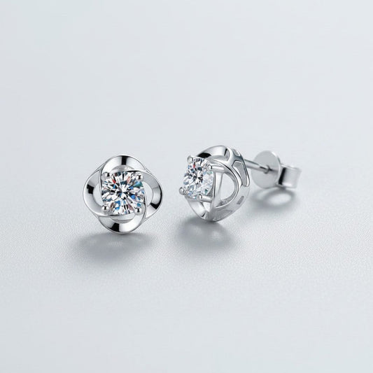Vooraanzicht en zijaanzicht van de platliggende ModaMelhor spiraalvormige oorknopjes van 925 sterling zilver met centraal geplaatste moissanite stenen.