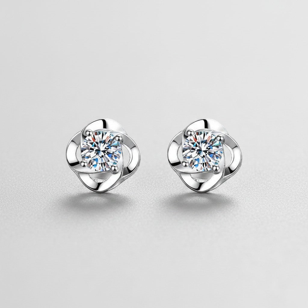 Symmetrisch vooraanzicht van het paar rechtopstaande ModaMelhor spiraalvormige oorknopjes van 925 sterling zilver met 0.6 karaat moissanite stenen.