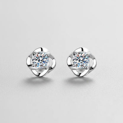 Symmetrisch vooraanzicht van het paar rechtopstaande ModaMelhor spiraalvormige oorknopjes van 925 sterling zilver met 0.6 karaat moissanite stenen.
