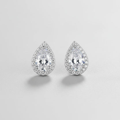 Symmetrisch vooraanzicht van het paar ModaMelhor druppelvormige oorknopjes van 925 sterling zilver met 2 karaat moissanite stenen en een glinsterende halo van zirkonia.